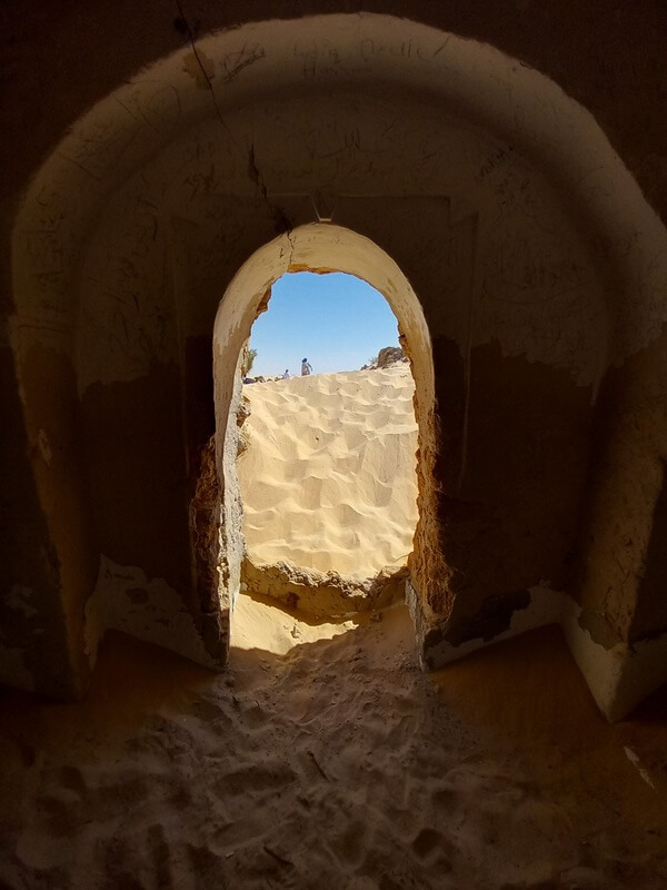 Porte ouverte dans un paysage désertique, symbole de transition, de passage et de nouveaux horizons.